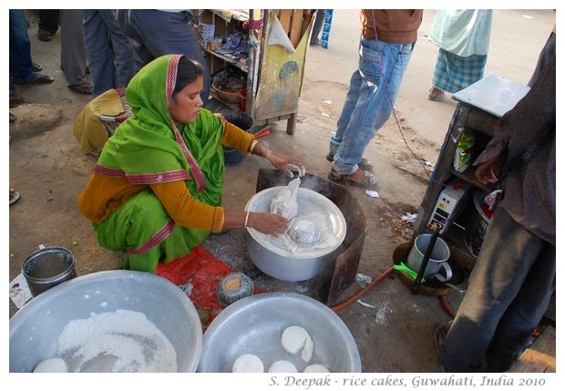 Woman cooking rice cakes on roadside, Guwahati, Assam, India