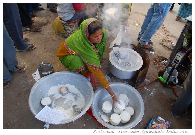 Woman cooking rice cakes on roadside, Guwahati, Assam, India