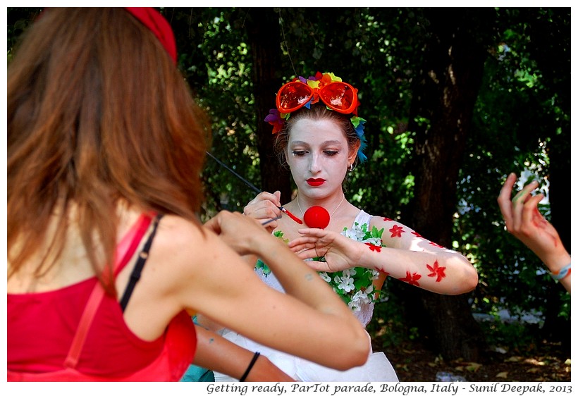 Girl painting red flowers on her body, Par Tot parade, Bologna, Italy - Images by Sunil Deepak