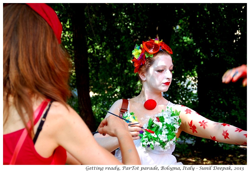 Girl painting red flowers on her body, Par Tot parade, Bologna, Italy - Images by Sunil Deepak