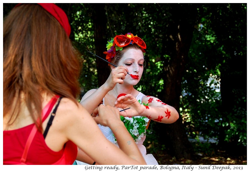 Girl painting red flowers on her body, Par Tot parade, Bologna, Italy - Images by Sunil Deepak